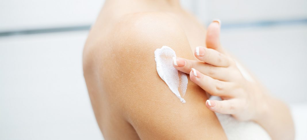 Women applying body lotion for moisturization