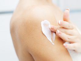 Women applying body lotion for moisturization