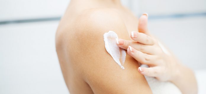 Women applying body lotion for moisturization